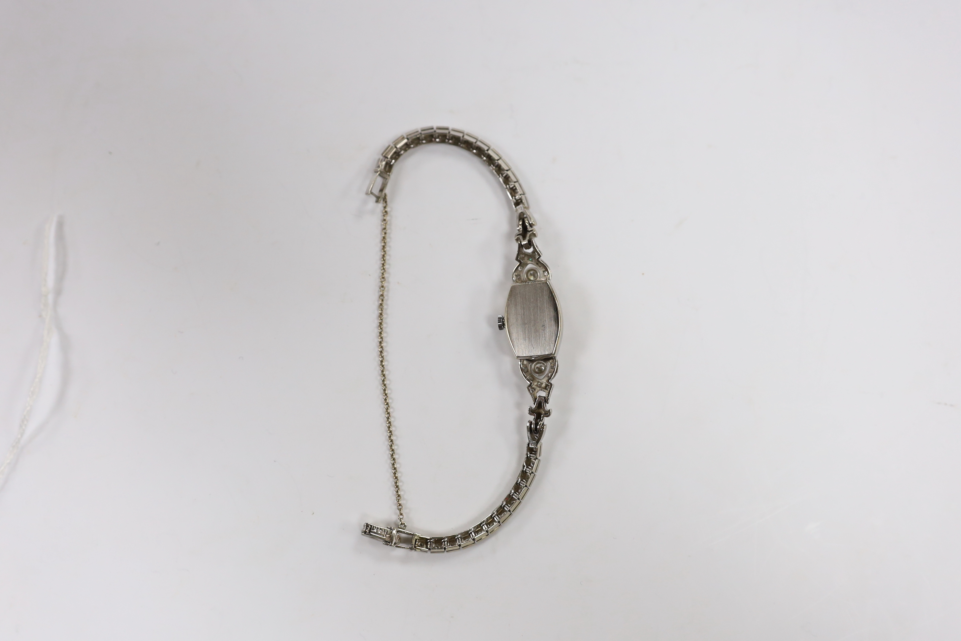 A lady's America 14k white metal and diamond cluster set manual wind cocktail watch, with diamond set bezel, lugs and bracelet, approx. 15cm, gross weight 18.9 grams, with safety chain.